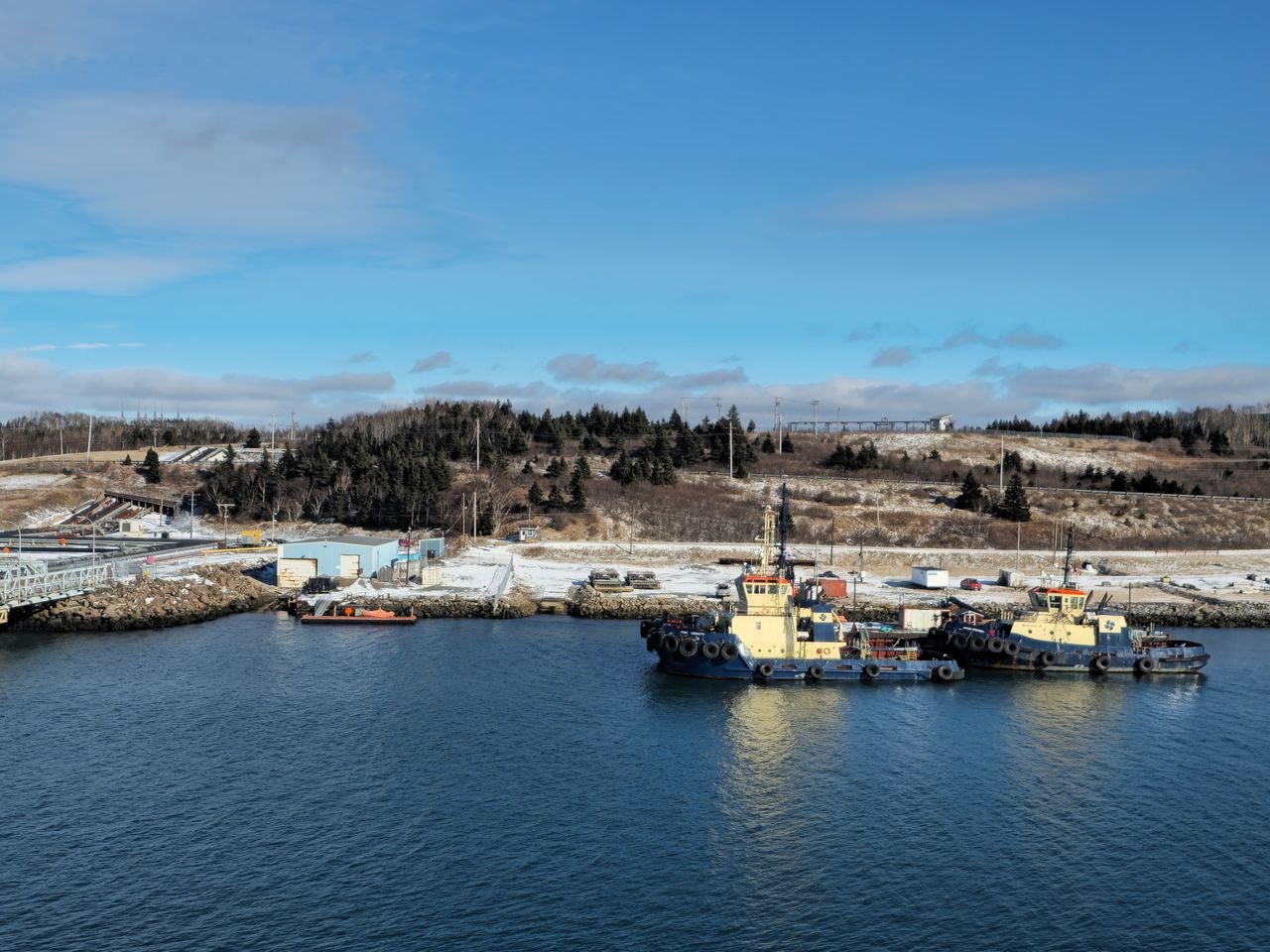 Tugboats docked by a snowy shore at Point Tupper, Nova Scotia.